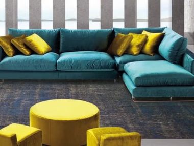 sofa chaiselong azul con cojines mostaza y pufs mostaza