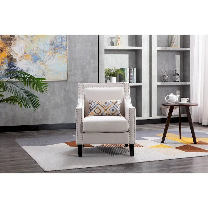Sillón de tela de lino con detalles de tachuelas y patas de madera maciza