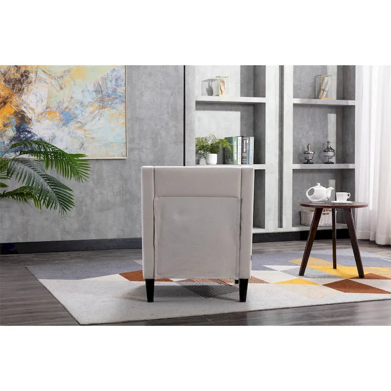 Sillón de tela de lino con detalles de tachuelas y patas de madera maciza